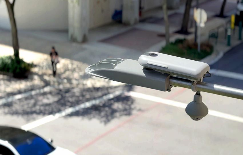 Public Ubicquia image of UbiHub hardware mounted beneath a streetlight above a city sidewalk
